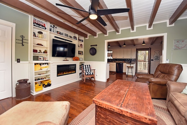 living room featuring built in shelves, dark hardwood / wood-style flooring, beam ceiling, wooden ceiling, and ceiling fan