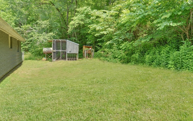209 Vengeance Creek Rd, Marble, NC 28905 - view of green lawn with exterior structure, an outdoor structure, and a wooded view