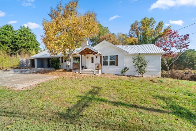 ranch-style home featuring a carport, a front yard, and covered porch