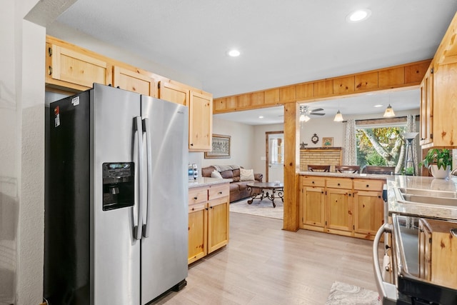 kitchen featuring stainless steel refrigerator with ice dispenser, sink, light wood-type flooring, light brown cabinetry, and decorative light fixtures