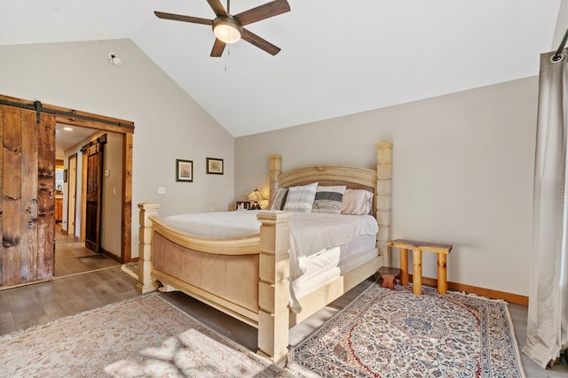 bedroom with a barn door, ceiling fan, lofted ceiling, and wood-type flooring