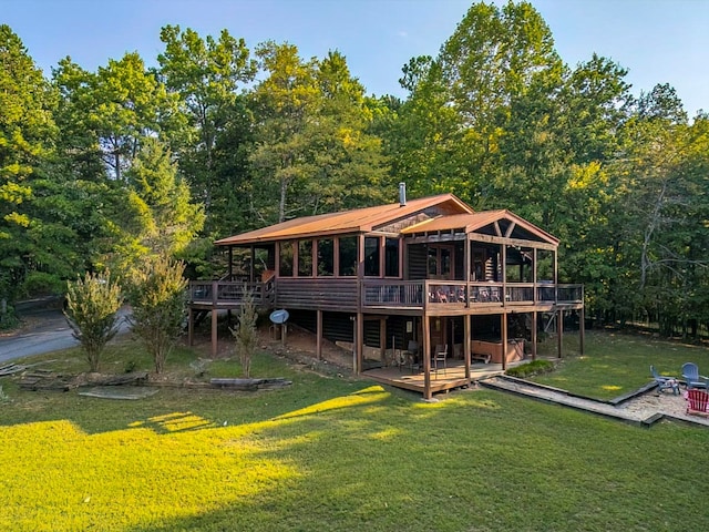 back of house featuring a lawn and a wooden deck