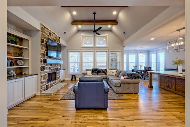 living room featuring a fireplace, beam ceiling, high vaulted ceiling, and light wood-type flooring