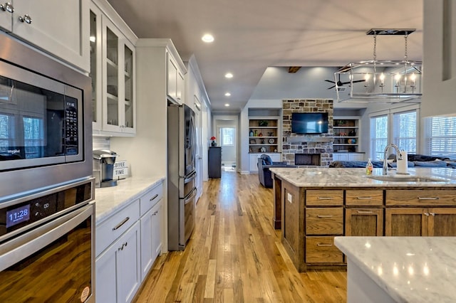 kitchen featuring light stone countertops, appliances with stainless steel finishes, sink, and white cabinets