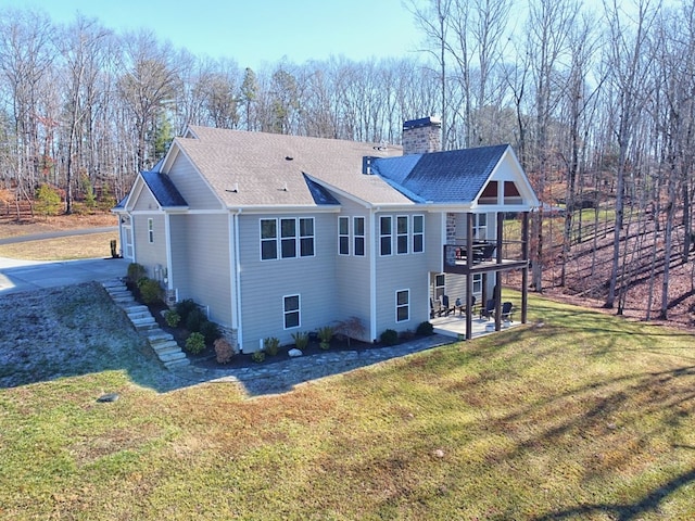 rear view of property with a patio and a lawn