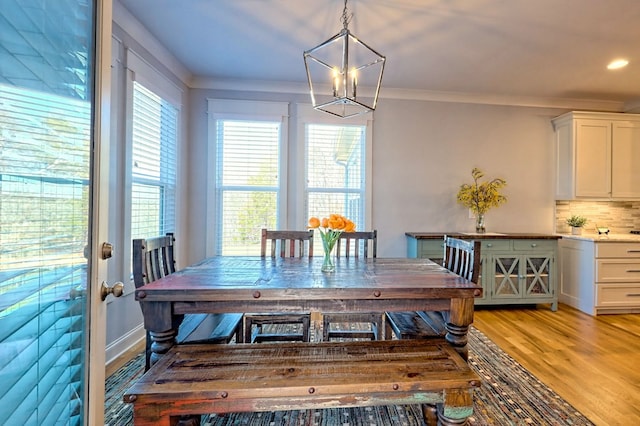 dining room featuring crown molding, a chandelier, and light hardwood / wood-style flooring