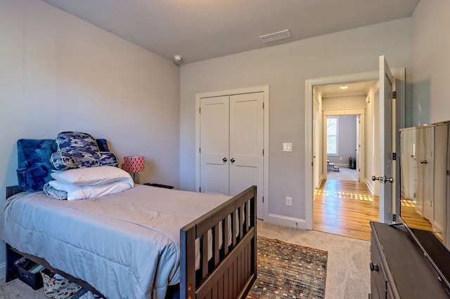 bedroom featuring light carpet and a closet