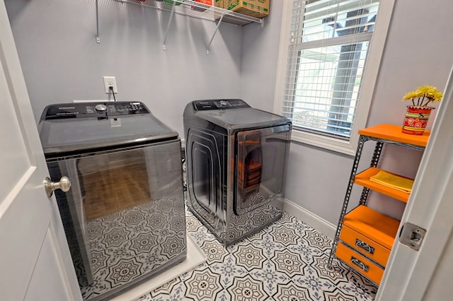 clothes washing area featuring separate washer and dryer and light tile patterned floors