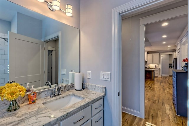 bathroom with vanity, hardwood / wood-style floors, and backsplash