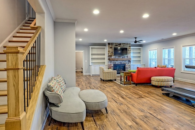 living room featuring ornamental molding, a fireplace, and wood-type flooring