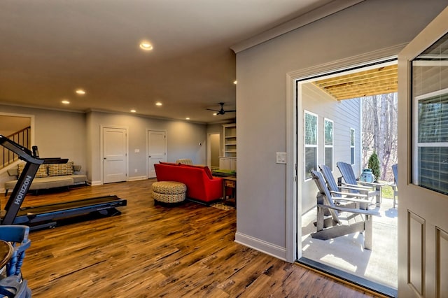 exercise room with ornamental molding, hardwood / wood-style floors, and ceiling fan