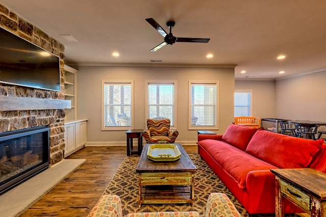 living room featuring crown molding, a fireplace, dark hardwood / wood-style floors, and ceiling fan