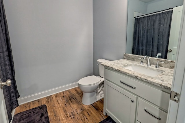 bathroom with vanity, toilet, and hardwood / wood-style floors