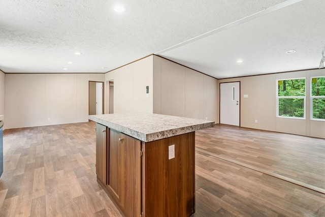 220 Jetty Dr, Ellijay, GA 30540 - kitchen featuring light wood-style floors, open floor plan, light countertops, a kitchen island, and a textured ceiling