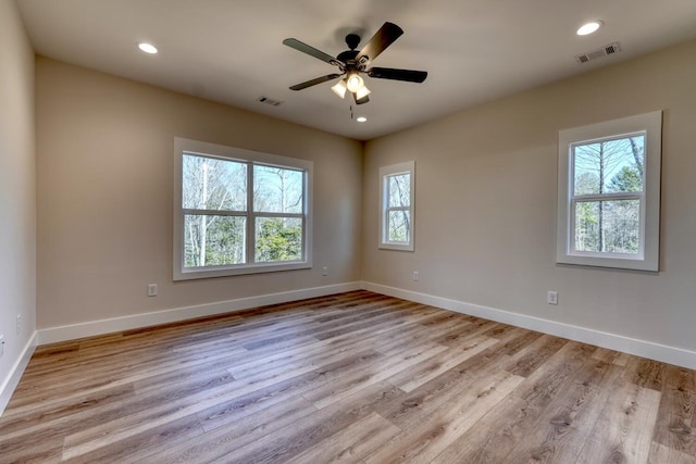 empty room featuring light wood finished floors, recessed lighting, visible vents, and baseboards