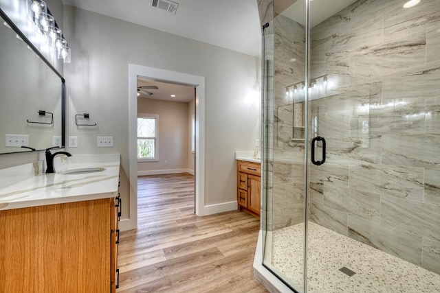 bathroom featuring visible vents, a shower stall, vanity, and wood finished floors