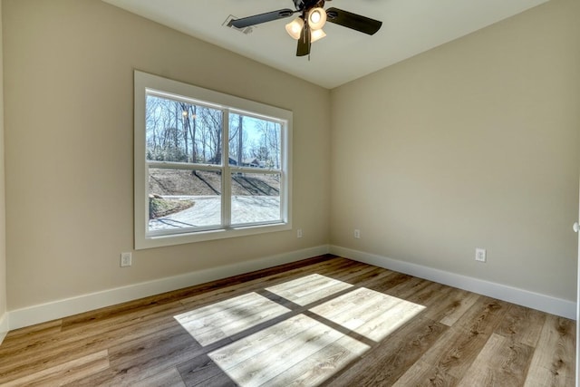 spare room with baseboards, visible vents, and light wood-style floors