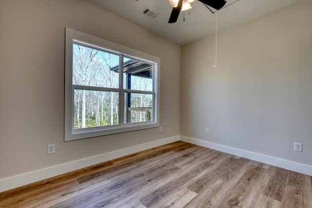 unfurnished room featuring baseboards, ceiling fan, visible vents, and light wood-style floors