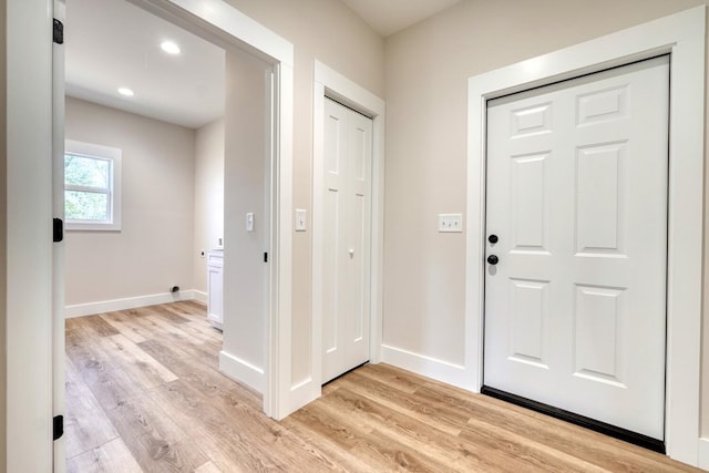 foyer featuring light wood-type flooring, baseboards, and recessed lighting