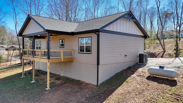 view of home's exterior featuring roof with shingles, board and batten siding, and cooling unit