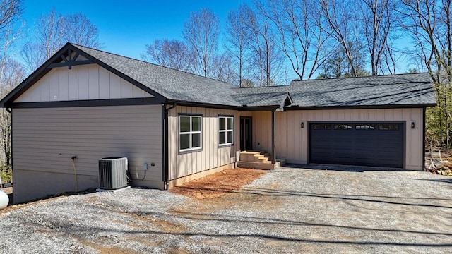 view of front of home featuring central AC unit, a garage, driveway, roof with shingles, and board and batten siding