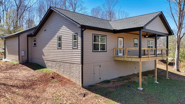 view of property exterior with ceiling fan and roof with shingles