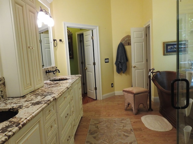 120 Sunrock Mountain Trc, Blue Ridge, GA 30513 - bathroom featuring double vanity, wood finished floors, a freestanding tub, and baseboards