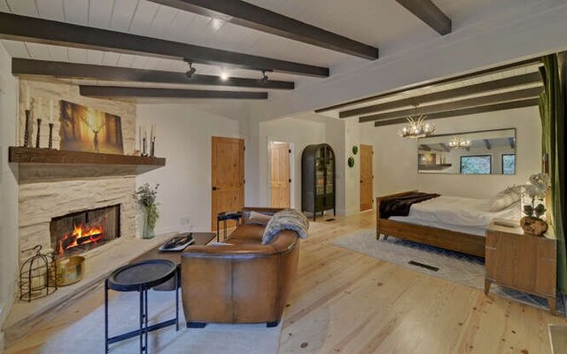 7670 Hiawassee Wilderness, Hiawassee, GA 30546 - living area with wood finished floors, a premium fireplace, beamed ceiling, and a chandelier
