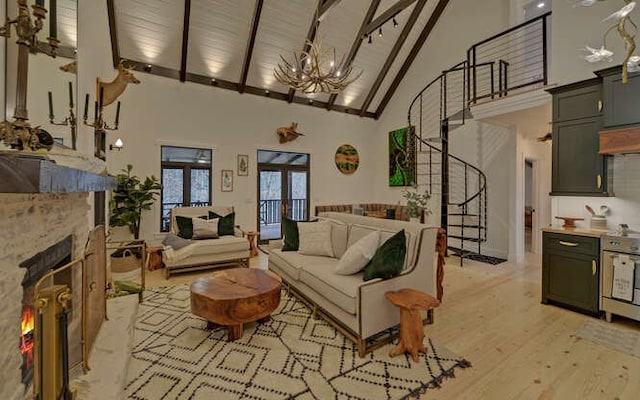 7670 Hiawassee Wilderness, Hiawassee, GA 30546 - living room with high vaulted ceiling, a chandelier, beamed ceiling, a lit fireplace, and light wood-style flooring