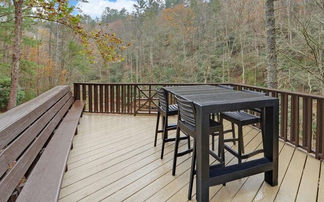 7670 Hiawassee Wilderness, Hiawassee, GA 30546 - wooden deck with outdoor dining space and a forest view