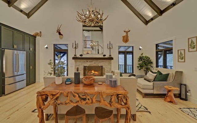 dining area featuring high vaulted ceiling, light hardwood / wood-style floors, and beam ceiling