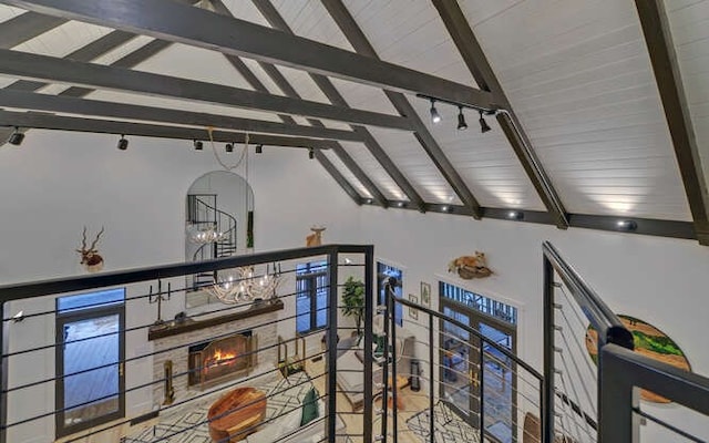 interior space with a fireplace, beamed ceiling, and a chandelier