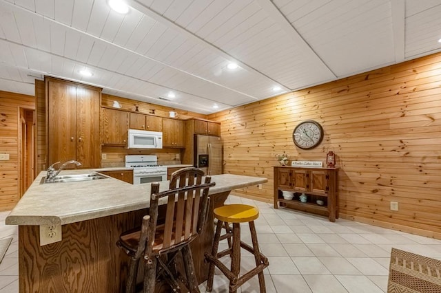 608 Pine Pass Cir, Mineral Bluff, GA 30559 - kitchen with a sink, white appliances, a peninsula, light countertops, and wooden walls
