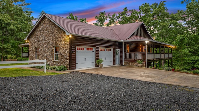 608 Pine Pass Cir, Mineral Bluff, GA 30559 - property exterior at dusk featuring stone siding, a garage, a porch, driveway, and metal roof