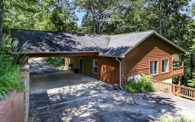 view of front facade featuring a wooden deck and a carport