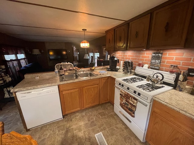 kitchen with white appliances, sink, pendant lighting, and kitchen peninsula