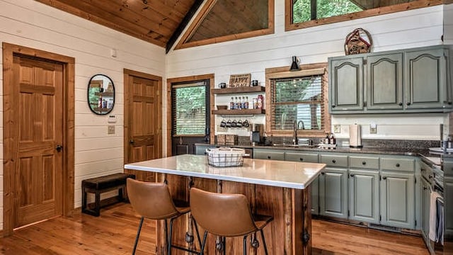 437 Spruce Cir, Mineral Bluff, GA 30559 - kitchen with light wood-style flooring, wooden ceiling, wooden walls, a sink, and a kitchen island