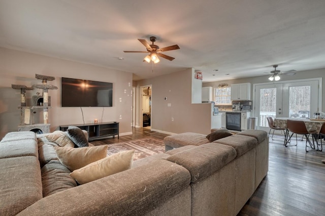 living area featuring ceiling fan, dark wood finished floors, and baseboards