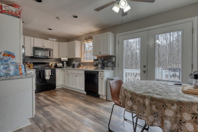 kitchen featuring decorative backsplash, white cabinets, wood finished floors, french doors, and black appliances