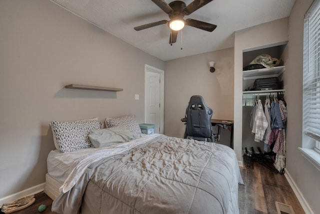 bedroom with a closet, wood finished floors, visible vents, and baseboards