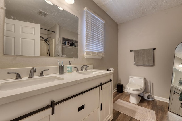 full bathroom featuring toilet, a shower, a sink, and wood finished floors