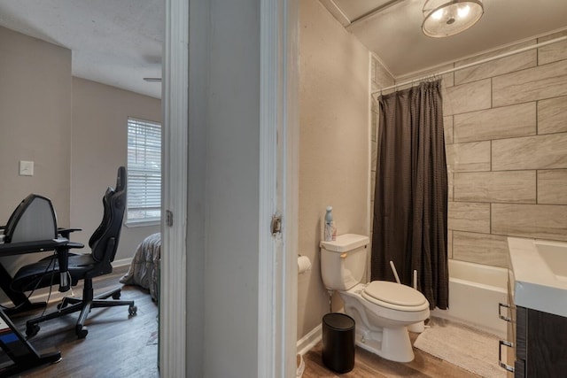 full bath with shower / tub combo, baseboards, toilet, and wood finished floors