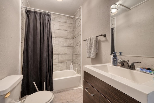 bathroom with a textured wall, vanity, toilet, and shower / bath combo with shower curtain