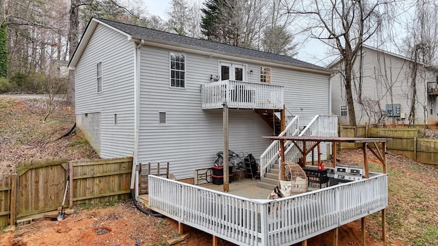 back of property with a fenced backyard, stairway, and a wooden deck