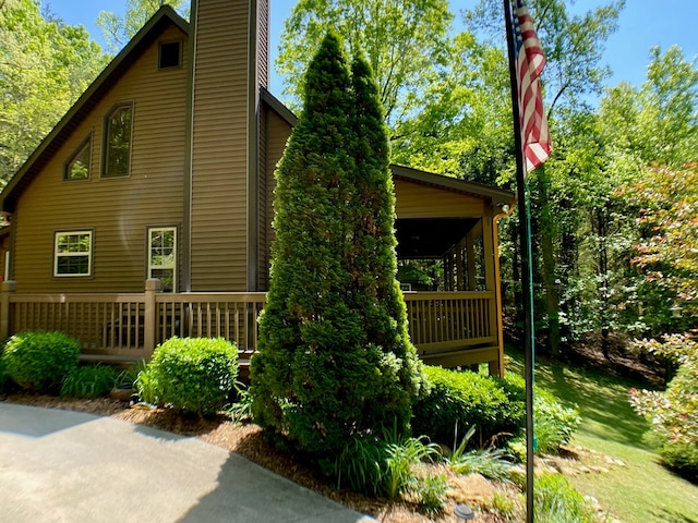 view of side of property featuring a chimney and a deck