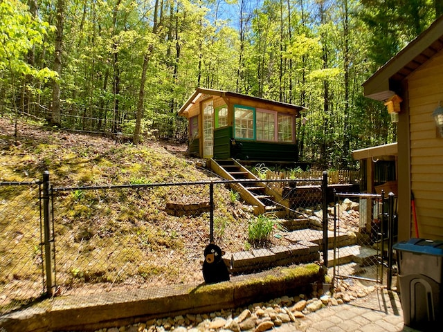 view of yard featuring a view of trees, fence private yard, and a gate
