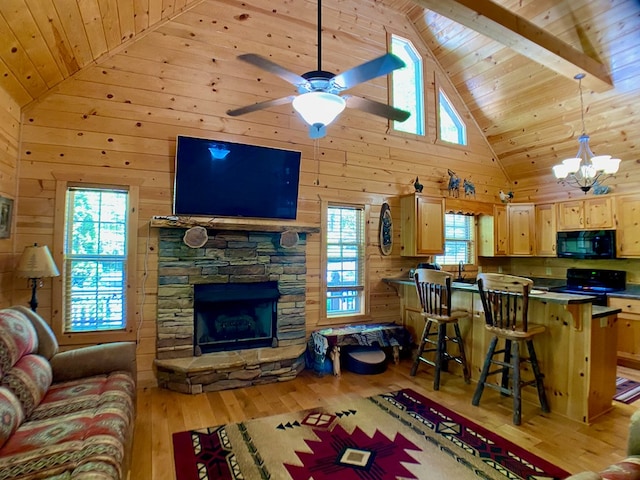 living area with wooden walls, a fireplace, light wood-style floors, high vaulted ceiling, and wood ceiling