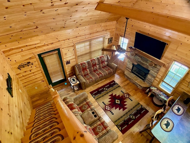 living room with wooden walls, a fireplace, and hardwood / wood-style floors