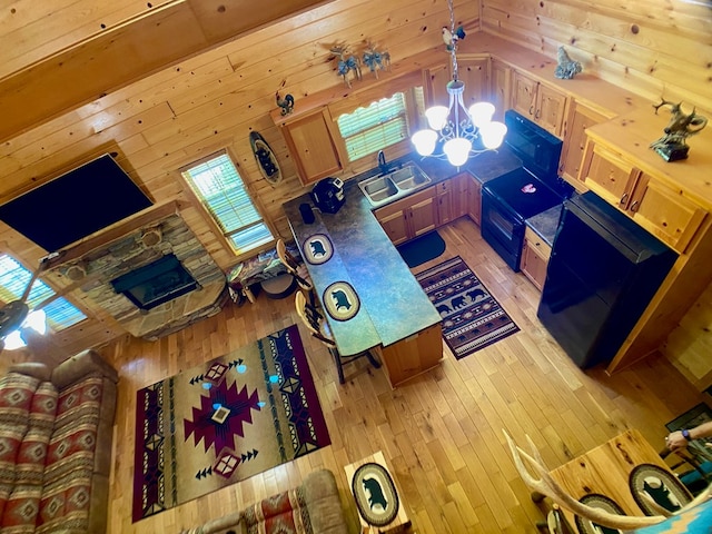 living room featuring wood walls, a chandelier, and light wood-style floors