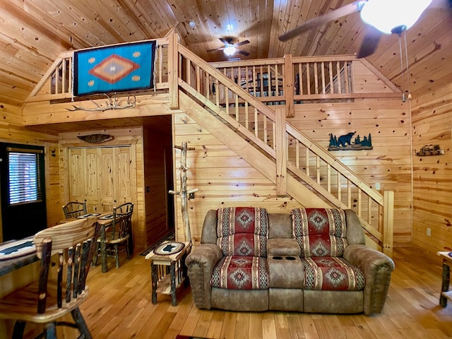 living area with wood walls, wood ceiling, stairs, and hardwood / wood-style flooring